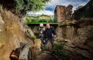 man stands by entrance to elaborate cave system in his backyard