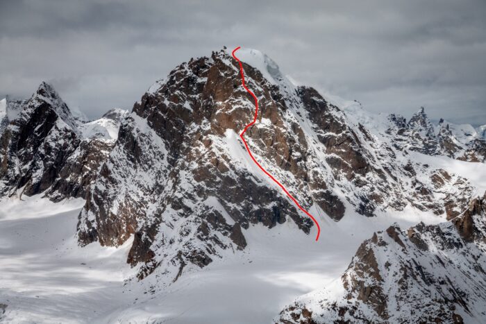 A route marked in red on a photo of a mixed peak. 