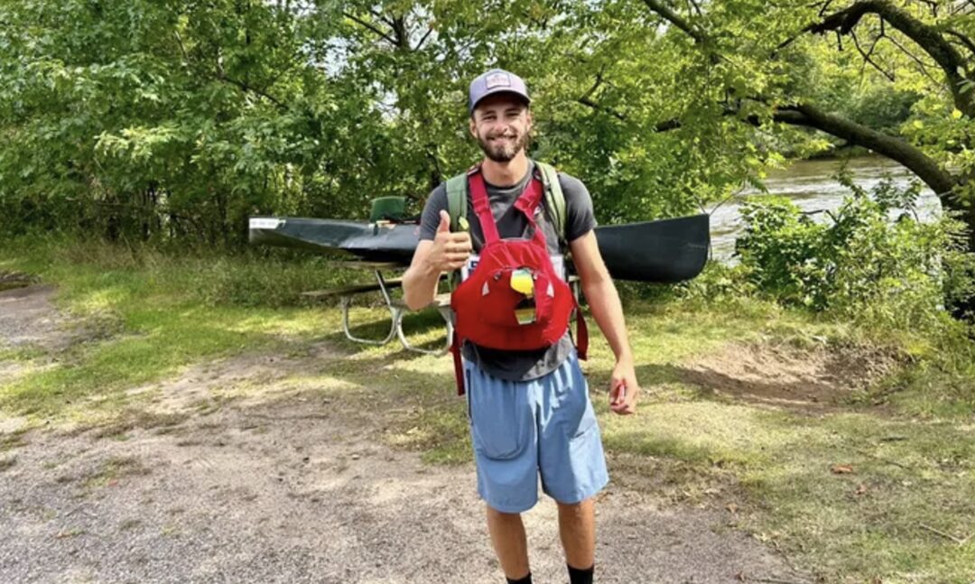 Kyle beside canoe