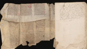 A photograph of a medieval manuscript tucked into the binding of a book.